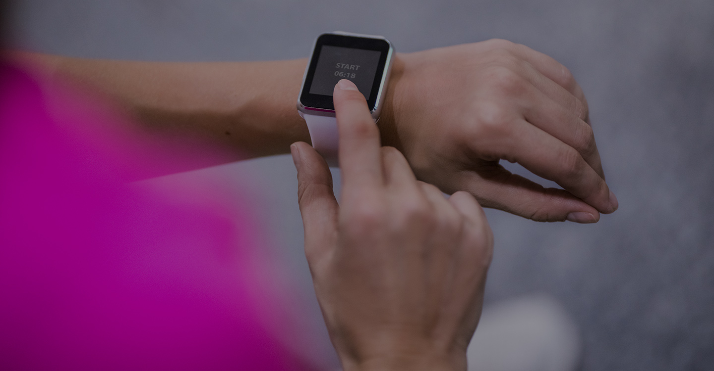 Woman checking a health monitor on her wrist while out walking