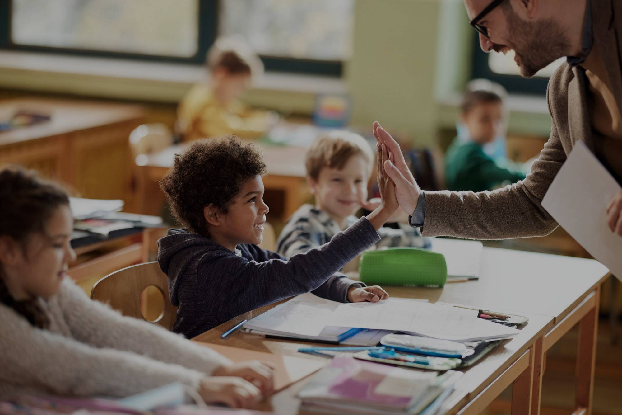 Young student hi-fives his teacher