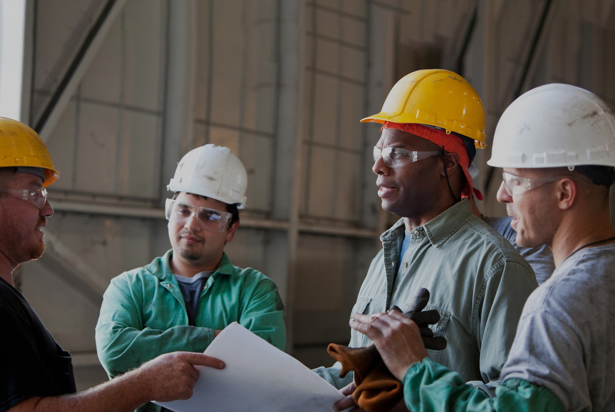 Construction workers in hard hats talking about a job.