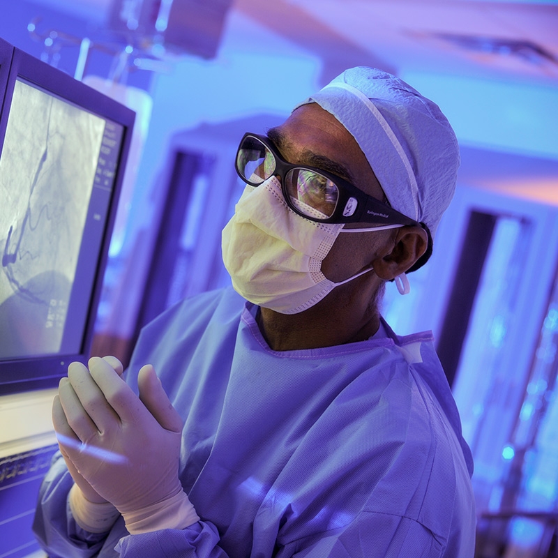 A diabetes specialist in surgical scrubs reviews a diabetic patient's test results