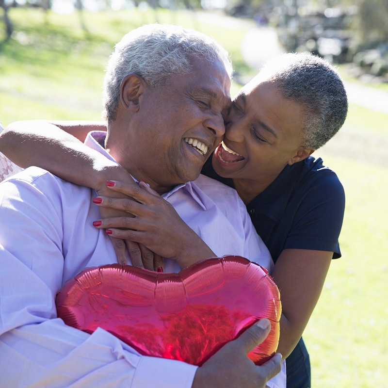 A couple embracing each other outside at a park