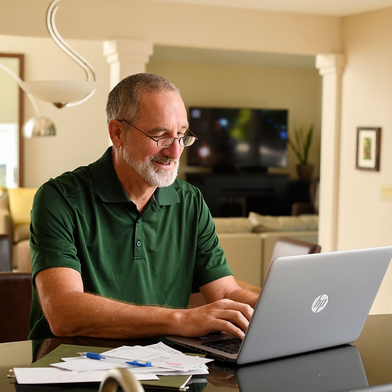 A man reviews additional diabetic health resources on his computer in a home office